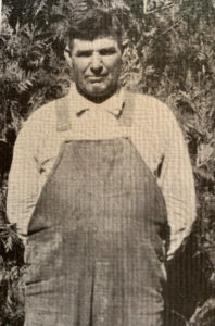 Newspaper photograph of a man in overalls