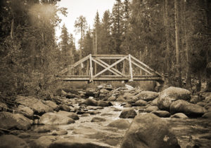Image of a wooden bridge ove a rocky river